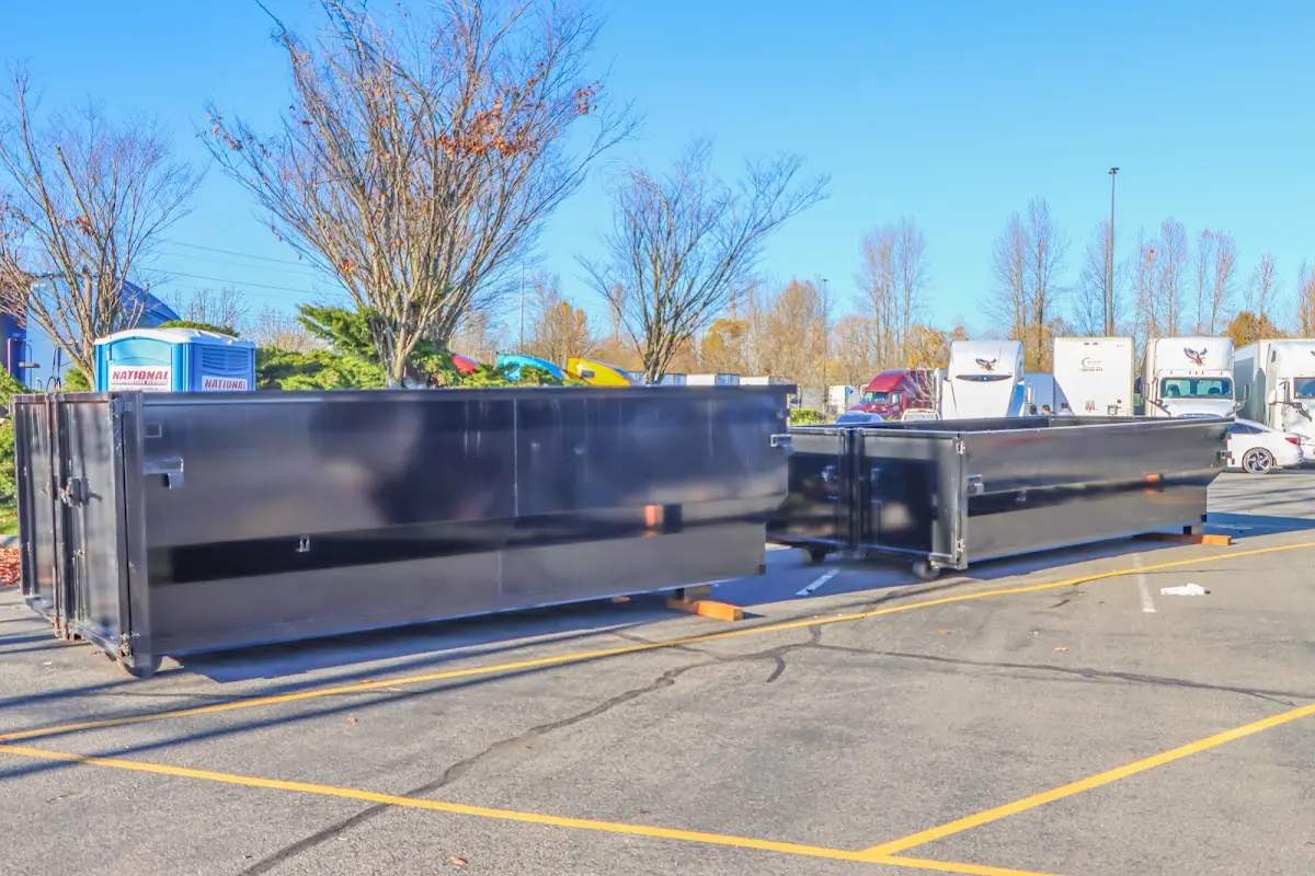 Professional dumpster rental service with roll-off container on residential driveway in Macomb